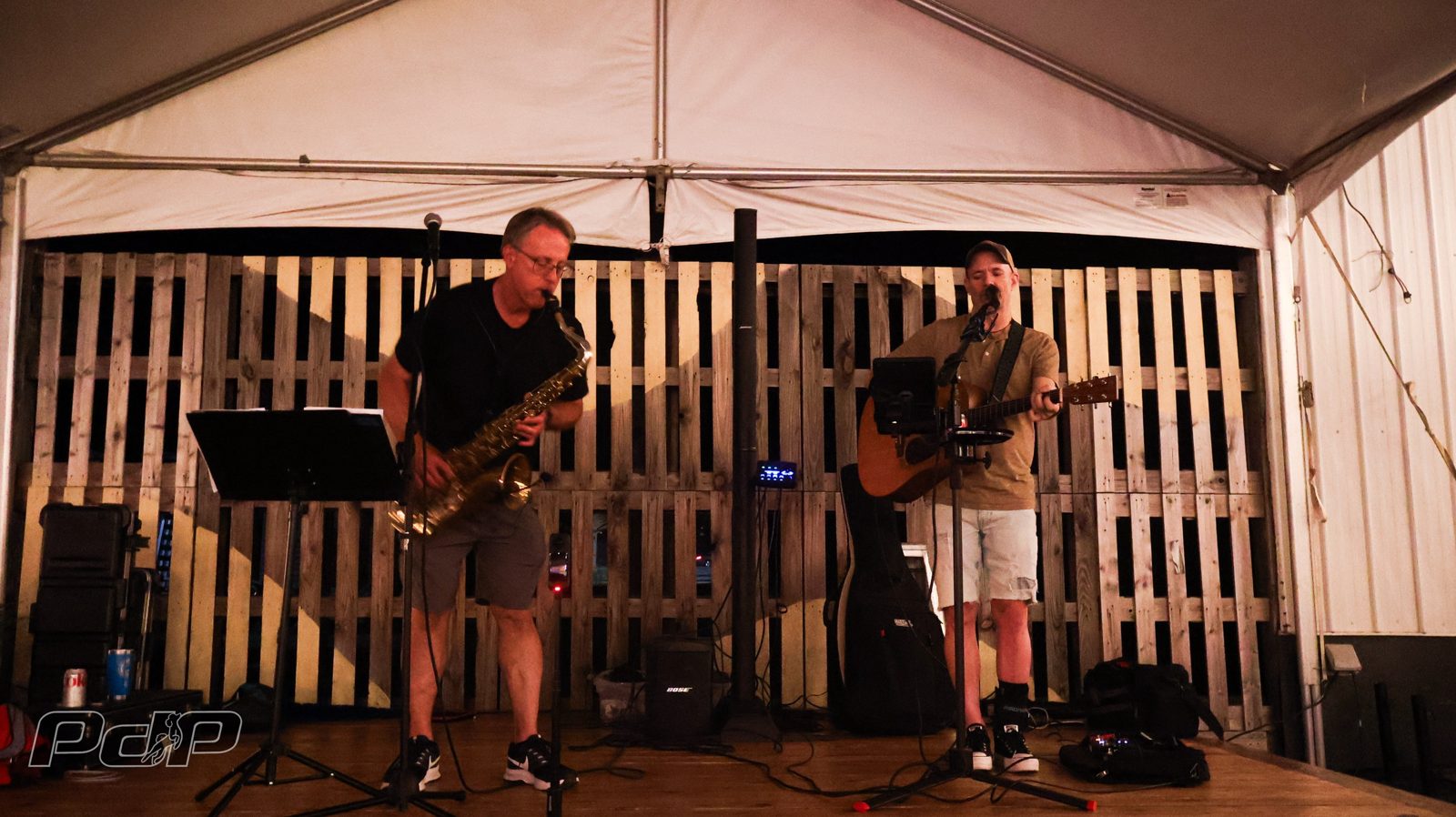 Chris Hynum on saxophone and Sean Royle Smith on acoustic guitar performing under the tent